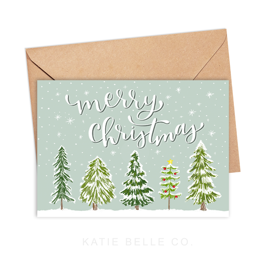 merry christmas. greeting card. snowy trees. christmas trees. snowy scene.Snowflakes. hand lettered font. Holiday greetings. A2 size. horizontal card design. Made by katie belle co