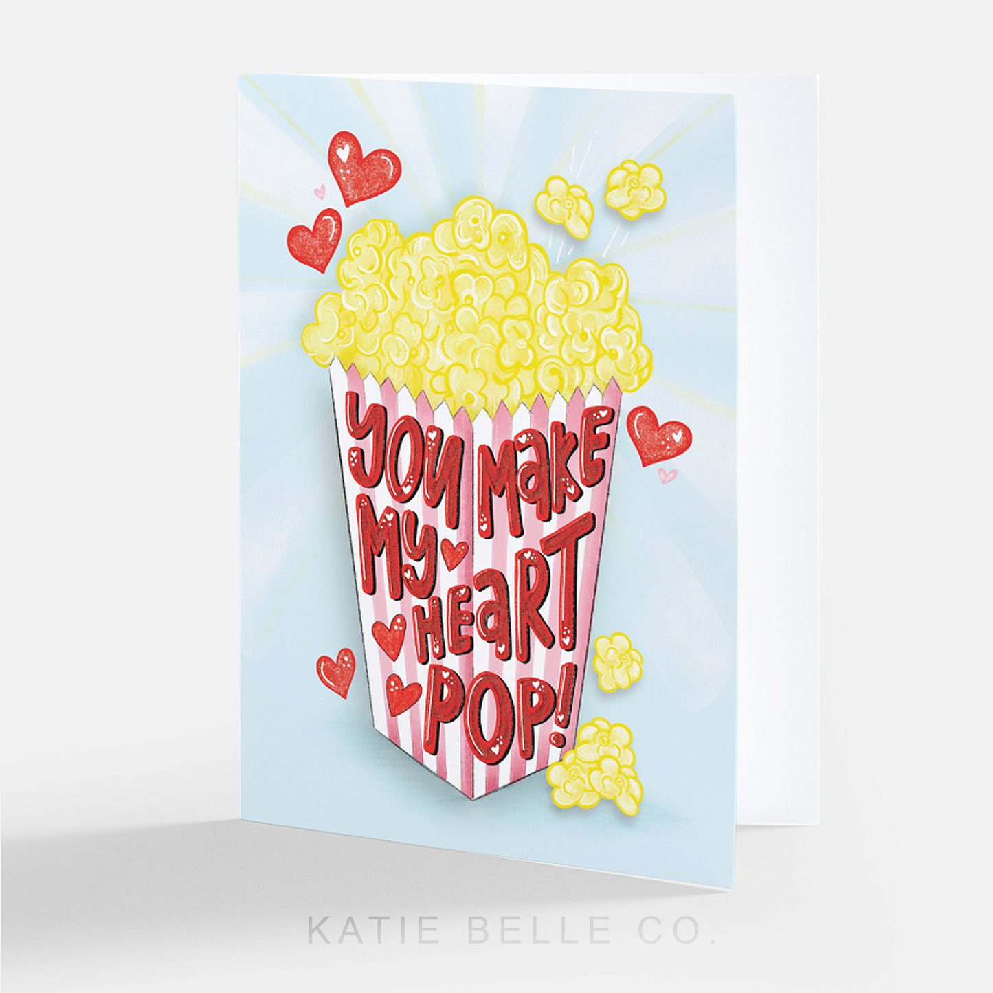 you make my heart pop. Popcorn card. greeting card. red floating hearts. popcorn bag. pink stripes. anniversary card. love greeting card. Valentine's day card. Popcorn lover gift. Katie Belle Co. 