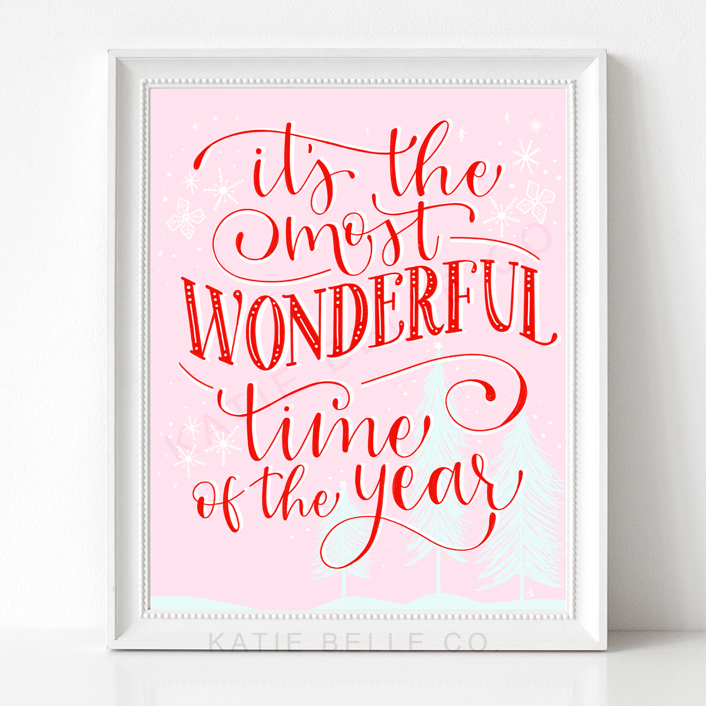 whimsical. pink. festive. christmas trees. snowflakes. red script font. christmas. holidays. holiday cheer. Our It's The Most Wonderful Time of the Year Art Print is a whimsical and festive addition to your holiday decor. Boasting charming pink hues and a delightful red script font, this piece will bring a touch of merry cheer to any room with its snowflakes, Christmas trees, and subtle holiday motifs. Unwrap some holiday magic this season with a classic touch. Katie belle co.